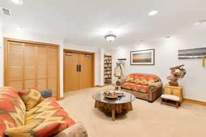 Carpeted living room featuring ornamental molding and recessed lighting. This photo is AI generated to reflect new carpet color.