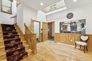 Entrance foyer featuring wood finished floors, stairway, a chandelier, a high ceiling, and recessed lighting