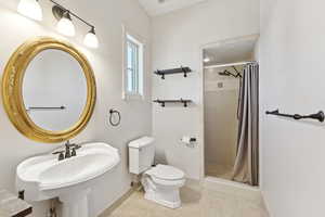 Bathroom with a shower stall and tile patterned floors