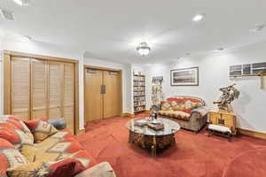 Carpeted living area with ornamental molding and recessed lighting