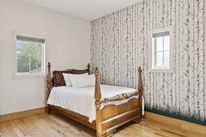 Bedroom featuring multiple windows and wood finished floors