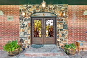 View of exterior entry featuring brick siding, french doors, and stone siding