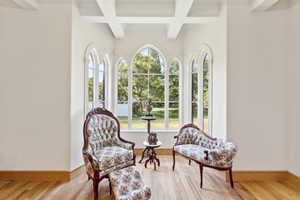 Living area featuring coffered ceiling, beamed ceiling, and wood finished floors