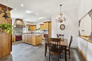 Dining room with a chandelier, recessed lighting, and stone tile flooring