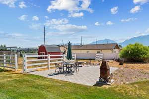 Fenced backyard featuring outdoor dining space, a patio, a mountain view, and a storage shed
