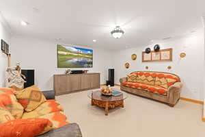 Carpeted living area featuring ornamental molding and recessed lighting . This photo is AI generated to reflect new carpet color.