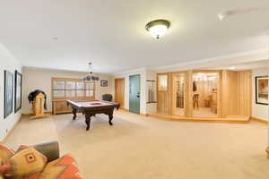 Game room with light carpet, crown molding, and billiards. This photo is AI generated to reflect new carpet color.