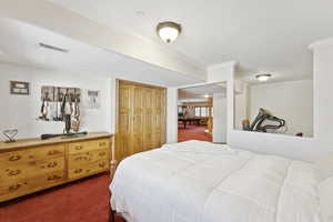 Potential Bedroom/Flex Room with dark carpet, ornamental molding, and a closet