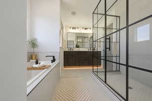 Full bath with a bath, a walk in shower, double vanity, and light tile patterned flooring