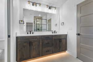 Full bath with a shower stall and double vanity