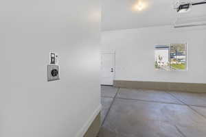 Garage with a garage door opener and baseboards