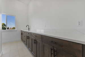 Laundry area featuring light tile patterned floors and baseboards