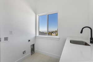Laundry area featuring electric dryer hookup, washer hookup, and light tile patterned floors