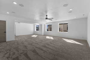 Carpeted empty room featuring a ceiling fan and recessed lighting