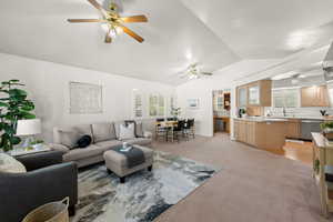 Living room featuring light colored carpet, lofted ceiling, and ceiling fan