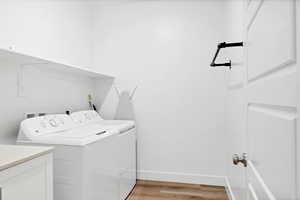Laundry area featuring light wood-style flooring and washing machine and dryer