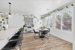 Dining area with light wood finished floors and recessed lighting