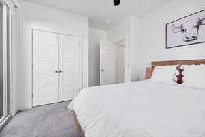 Carpeted bedroom with a closet and ceiling fan