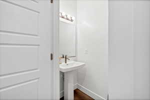 Bathroom featuring dark wood finished floors and baseboards