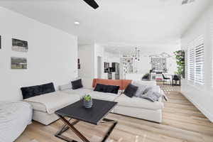 Living area with light wood-style flooring and recessed lighting