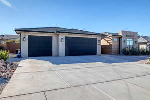 View of front of home with stucco siding, driveway, a garage, and a tile roof