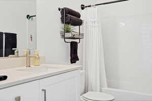 Full bath featuring shower / tub combo with curtain and vanity