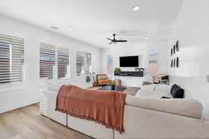 Living area featuring wood finished floors, a ceiling fan, and recessed lighting