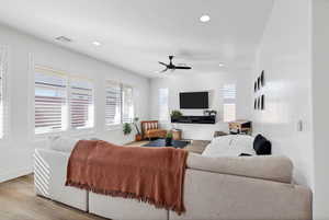 Living room with wood finished floors, ceiling fan, and recessed lighting