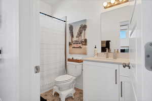 Bathroom featuring vanity, light tile patterned floors, and curtained shower
