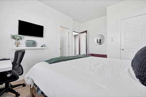 Carpeted bedroom with a desk