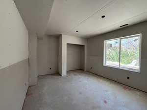 Unfurnished bedroom with unfinished concrete floors