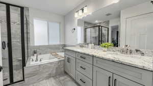 Full bathroom with a bath, a stall shower, and double vanity