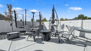 Fenced backyard with an outdoor fire pit and a patio area