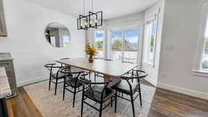 Dining room featuring dark wood-style floors and a chandelier