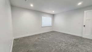 Carpeted spare room featuring recessed lighting and baseboards