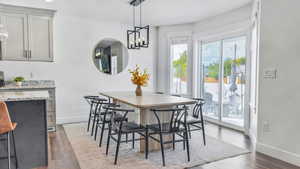 Dining area featuring dark wood-style floors and a chandelier