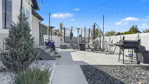 Fenced backyard with a patio area and a grill