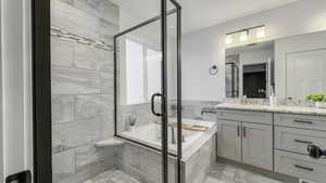 Full bathroom with vanity, a stall shower, and a bath