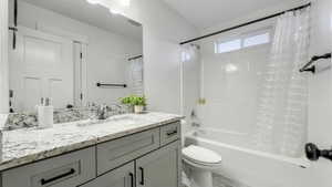 Bathroom with shower / bath combo with shower curtain and vanity