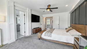 Carpeted bedroom featuring a ceiling fan and ensuite bathroom