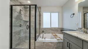Full bathroom with vanity, a bath, and a stall shower