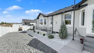 View of side of home featuring stucco siding and a fenced backyard