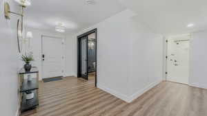 Foyer entrance with light wood-style flooring and baseboards