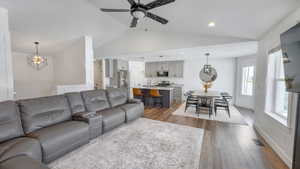 Living room with lofted ceiling, dark wood-style flooring, a ceiling fan, and recessed lighting