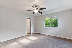 Empty room with light carpet and ceiling fan