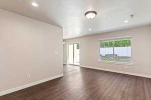 Spare room with dark wood finished floors, recessed lighting, and a textured ceiling