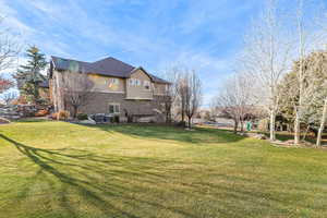 View of property exterior featuring brick siding and a yard