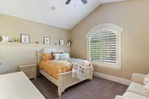 Bedroom featuring vaulted ceiling, carpet floors, and a ceiling fan