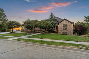 View of front of property with stone siding and a front yard