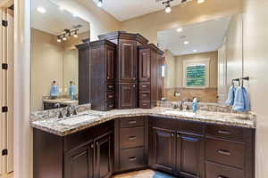 Bathroom featuring double vanity, recessed lighting, and rail lighting